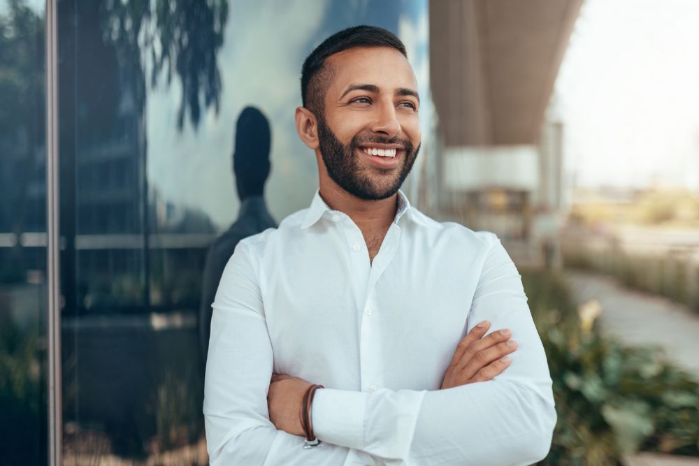 Smiling man with bright, healthy teeth in a professional setting, representing confidence after dental care