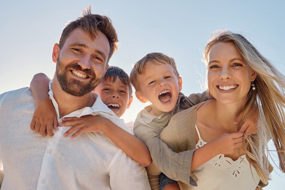 Smiling family with children showing healthy teeth, representing friendly, comprehensive family dental care