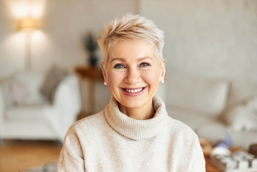 Smiling older woman with bright, healthy teeth, representing confident results from cosmetic or restorative dentistry