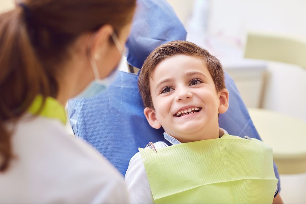 Child smiling in dental chair during a friendly, stress-free family dentistry visit