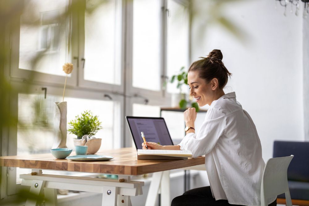 Woman working comfortably at desk, representing improved focus and energy after effective dental treatment