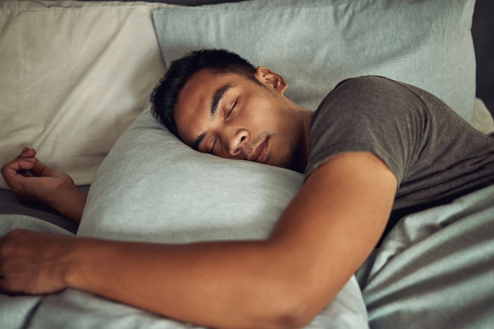 Man sleeping comfortably on his side, representing relief from sleep apnea with dental sleep treatment